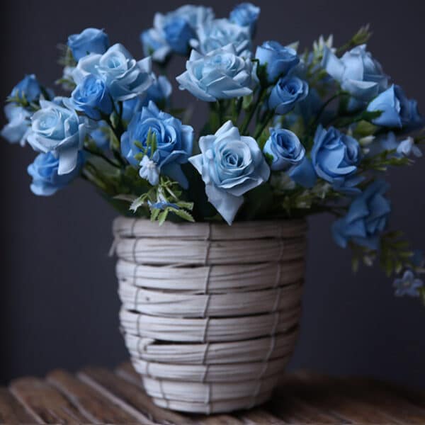 Bouquet de roses bleues dans un vase gris.