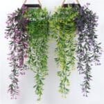 Photo de deux paniers de fleurs artificielles tombantes vertes et violettes