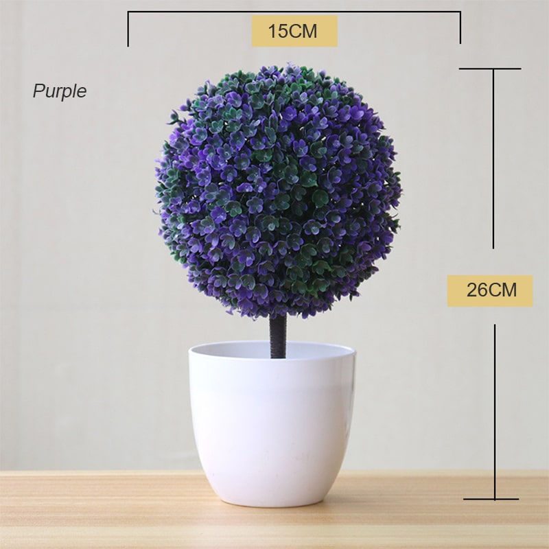 Plante artificielle en boule de couleur violette dans un pot blanc.