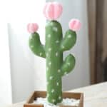 Photo d'un cactus artificiel avec 3 petites fleurs roses dans un pot