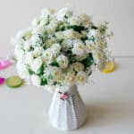 Bouquet de fleurs blanches en plastique dans un vase en terre cuite sur un fond blanc