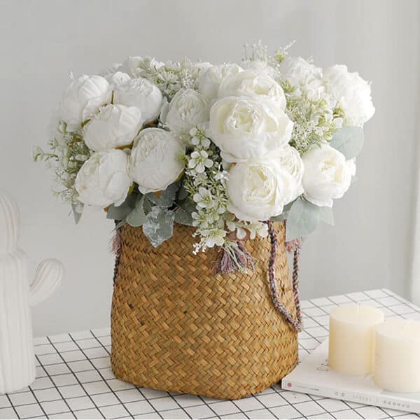Photo d'un bouquet de fleurs blanches de pivoine dans un sac posé sur une table