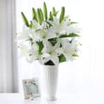 Bouquet de lys artificiel blanc dans un vase.