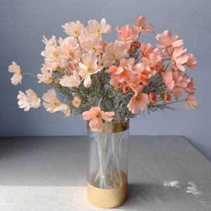 Bouquet de fleur artificielle de géranium blanc et orange dans un vase sur un table grise