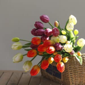 Bouquet de tulipes dans une panier en osier posé sur une table en bois