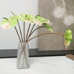 Tige artificielle Anthurium multicouleur dans un vase transparent.