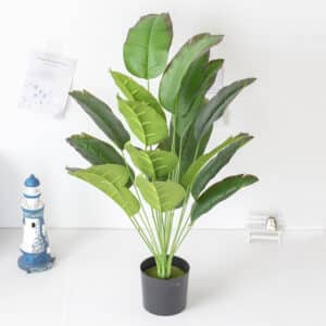 photo d'un pot avec des feuilles de bananier artificielles.