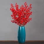 Baies rouges dans une vase bleu posé sur une table en bois