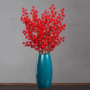 Baies rouges dans une vase bleu posé sur une table en bois